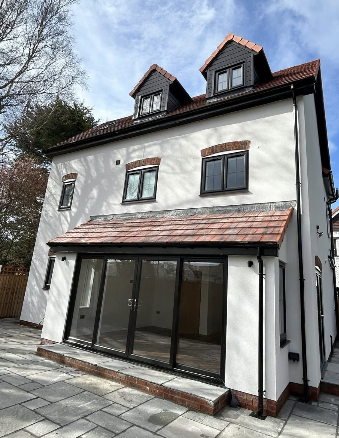 Re-rendered detached home with dormers and bifold doors