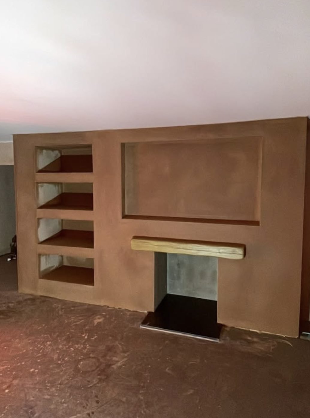 Plastered feature wall with shelving and oak mantel beam